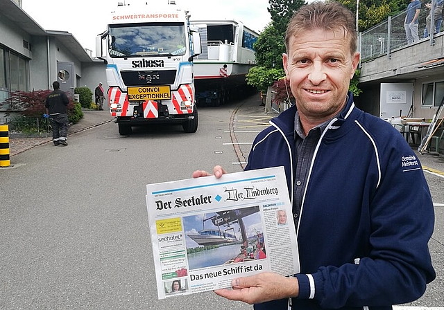 <em>Letzte Etappe an Land:</em> Ueli Haller, Geschäftsführer der Schifffahrtsgesellschaft, präsentiert am Tag der Einwasserung vor der MS 2018 die Titelseite dieser Zeitung. Fotos: Fritz Thut
