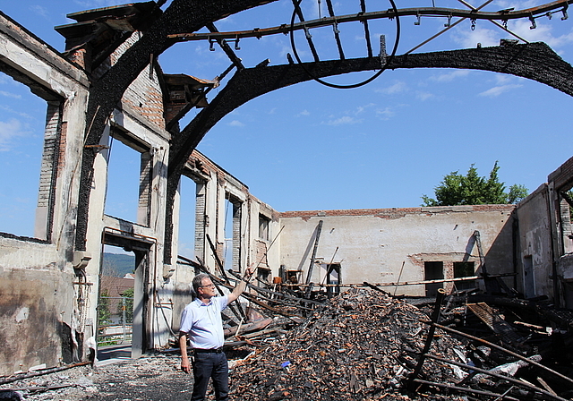 Schutt und Asche: Gemeindeammann Herbert Anderegg inmitten der Brandruine. Foto: Alfred Gassmann