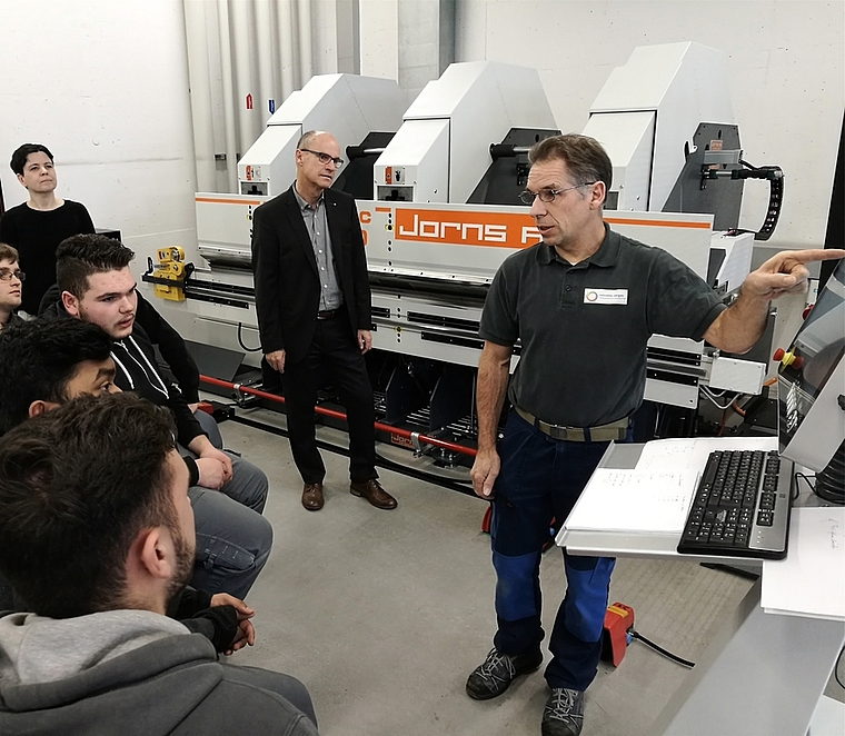 Moderne Technik: Vor der neuen Langabkantmaschine an der Berufsschule Lenzburg instruiert Fachlehrer Andreas Suter Lernende.Foto: Fritz Thut