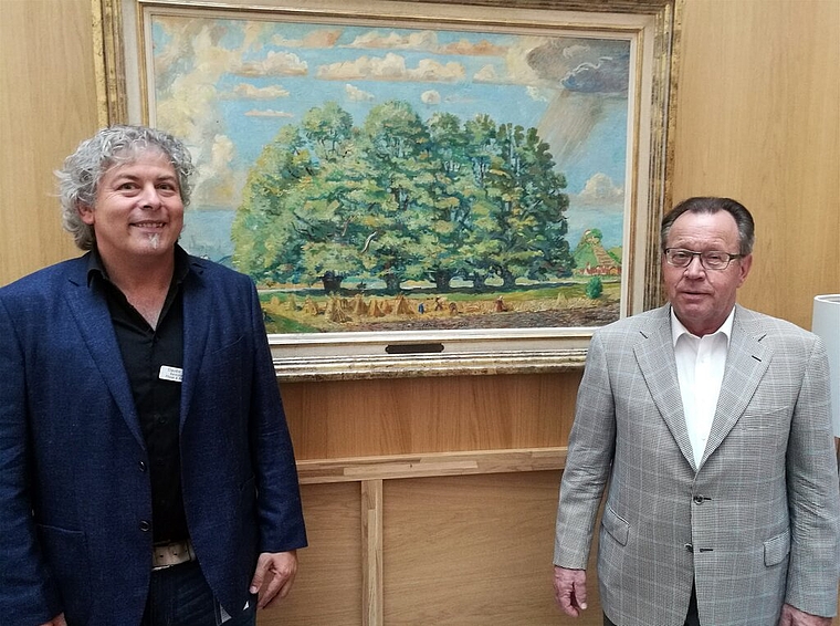«Lenzburger Ansichten» im Alterszentrum: Claudio Pinetti, stellvertretender Zentrumsleiter, und Urs F. Meier, Stiftungsratspräsident Museum Burghalde, vor dem Bild «Fünflinden» von Theo Glinz. Foto: Fritz Thut