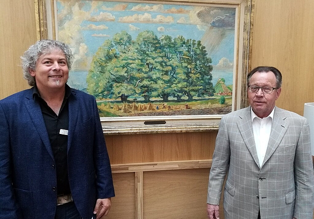 «Lenzburger Ansichten» im Alterszentrum: Claudio Pinetti, stellvertretender Zentrumsleiter, und Urs F. Meier, Stiftungsratspräsident Museum Burghalde, vor dem Bild «Fünflinden» von Theo Glinz. Foto: Fritz Thut