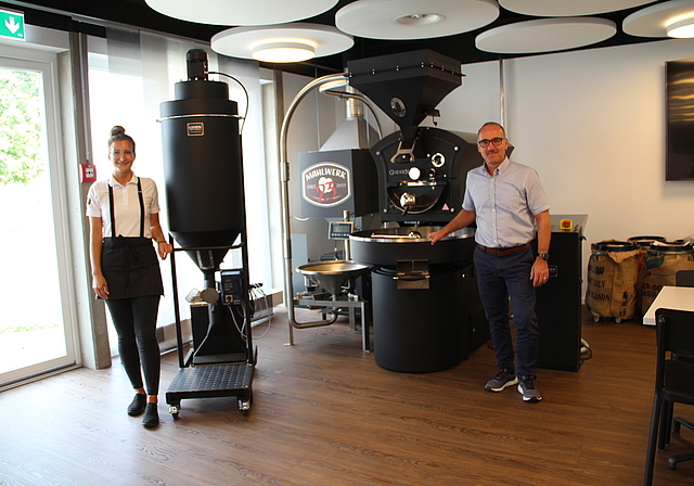 Schweizweit in einem Café einzigartig: Barista Tatjana Lukic und Geschäftsführer Martin Bhend mit der imposanten Kaffeerösterei. Foto: Carolin Frei