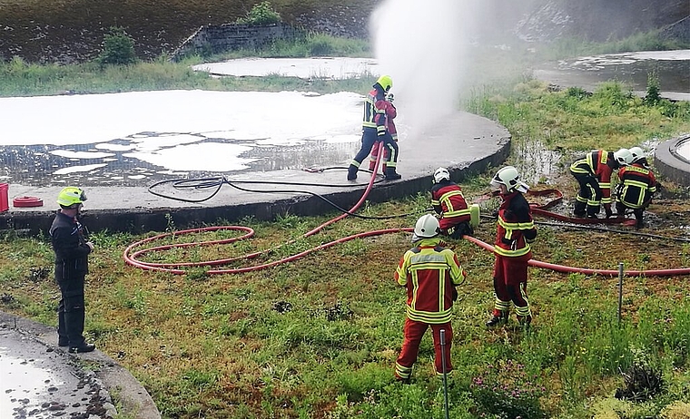 <em>Profitierten von idealen Übungsobjekten:</em> Teilnehmer am Feuerwehr-Einführungskurs Gruppenführer bei einer Einsatzübung mit Wasser und Schaum. Foto: Fritz Thut