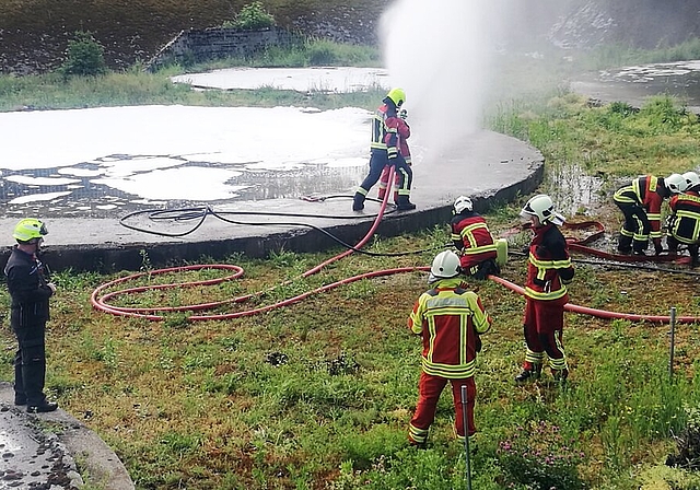 <em>Profitierten von idealen Übungsobjekten:</em> Teilnehmer am Feuerwehr-Einführungskurs Gruppenführer bei einer Einsatzübung mit Wasser und Schaum. Foto: Fritz Thut
