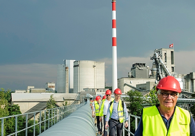 Schwindelfrei und keine Höhenangst: Mit roten Helmen geschützt und passend zum farbigen Kamin im Hintergrund war der Marsch entlang dem neuen Förderband pure Faszination.