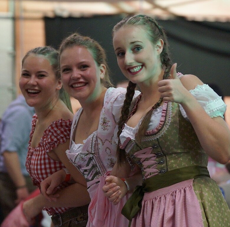 <em>Verbreiten gute Laune:</em> Drei junge Frauen im Dirndl am Oktoberfest. Foto: rubu