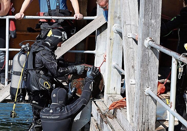 Mit vereinten Kräften: Freiwillige Taucher bergen das schwere Metallfass. Foto: Tanja Isler
