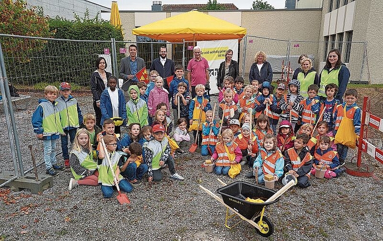 Die Baustelle ist eröffnet: Kinder und Bauleute freuen sich gemeinsam auf den Neubau. Foto: Mirjam Stutz