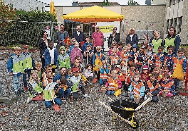 Die Baustelle ist eröffnet: Kinder und Bauleute freuen sich gemeinsam auf den Neubau. Foto: Mirjam Stutz