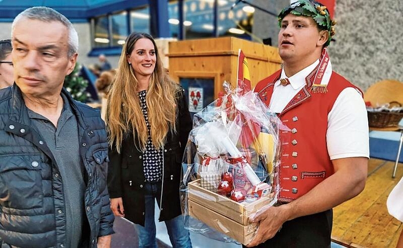 Geschenkkorb vom früheren Wohnort: Gemeinderat Patrick Braun und Gemeindeammann Katja Früh mit dem desertierten «Eidgenossen» Nick Alpiger. Foto: Fritz Thut