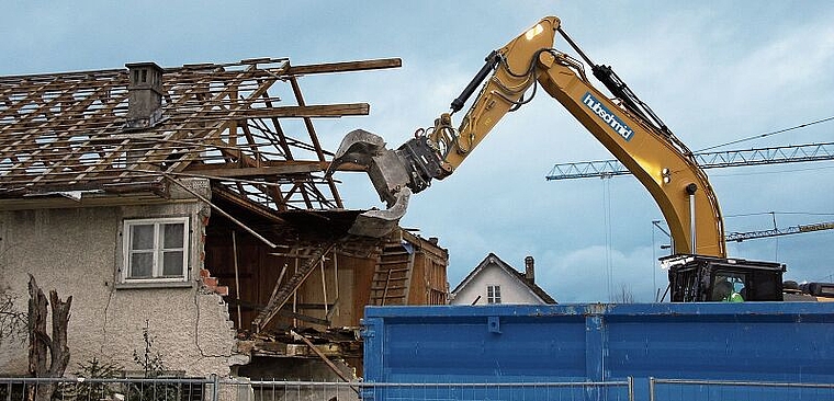 Die letzten Stunden haben geschlagen: Der Bagger macht sich an das Dachgeschoss des Wohnhauses Moser. Foto: Alfred Gassmann