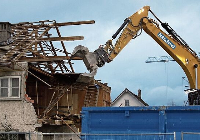 Die letzten Stunden haben geschlagen: Der Bagger macht sich an das Dachgeschoss des Wohnhauses Moser. Foto: Alfred Gassmann