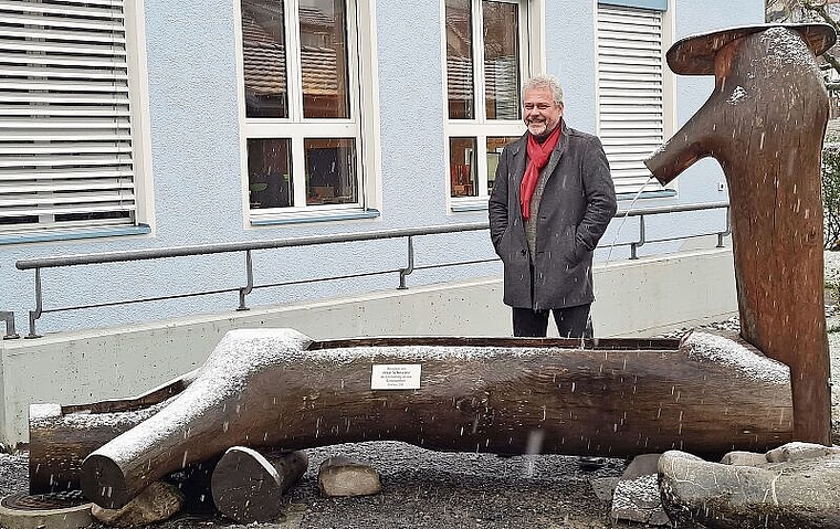 Anlässlich des Regionalturnfests von einem Dintiker aus heimischem Holz gefertigt worden: Ruedi Würgler vor dem Brunnen, der nun den Platz vor dem Gemeindehaus aufwertet. Foto: Carolin Frei