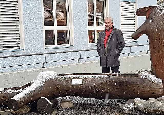 Anlässlich des Regionalturnfests von einem Dintiker aus heimischem Holz gefertigt worden: Ruedi Würgler vor dem Brunnen, der nun den Platz vor dem Gemeindehaus aufwertet. Foto: Carolin Frei