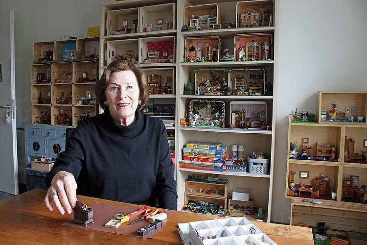 Christin Furter-Hilfiker an ihrem Arbeitstisch: Die Seniorin baut Welten im Mini-Format. Jedes Puppenhaus beginnt mit der Küche. Foto: Debora Hugentobler