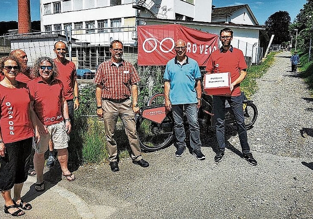 Petitionsaushändigung am Dammweg: Begleitet von Mitgliedern übergibt Pro-Velo-Lenzburg-Präsident Michael Oberle (rechts) Stadtrat Martin Stücheli und Christian Brenner (Abteilungsleiter Tiefbau und Verkehr) die 315 Unterschriften. Foto: Fritz Thu