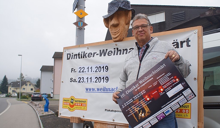 <em>Seit dem Start dabei:</em> Heinz Fischer vor dem Plakat des 10. Dintiker Weihnachtsmarkts. Foto: Ruedi Burkart