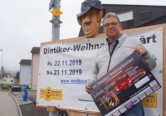 <em>Seit dem Start dabei:</em> Heinz Fischer vor dem Plakat des 10. Dintiker Weihnachtsmarkts. Foto: Ruedi Burkart