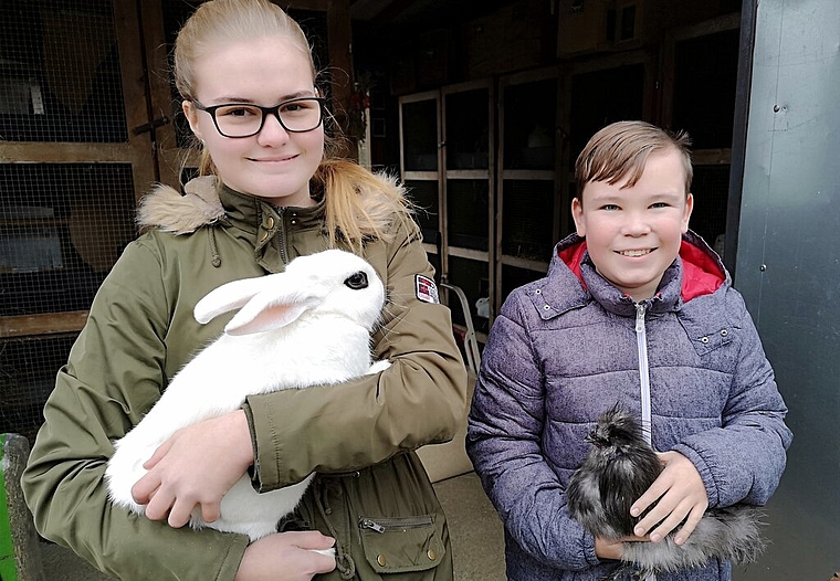 <em>Nehmen am Wochenende an der Schweizerischen Jugendmeisterschaft Kleintierzucht in Lenzburg teil:</em> Selina Vogler mit ihrem Hotot-Kaninchen Merlino und Dylan Connor Mathys, hier mit einem Zwergseidenhahn Blau.Foto: Fritz Thut