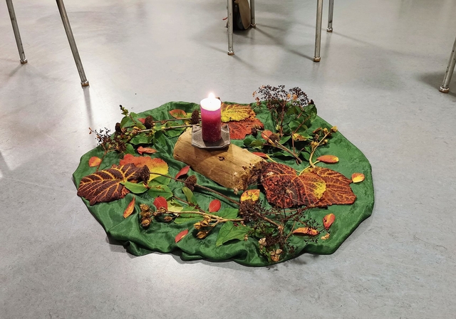 In der Mitte des Stuhlkreises eine Kerze und buntes Herbstlaub.Foto: Verena Schmidtke