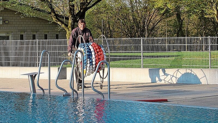 Noch sind letzte Arbeiten zu erledigen, bevor am Samstag die Badi öffnet: Badmeister Georges Hächler mit den Schwimmleinen. Foto: Carolin Frei