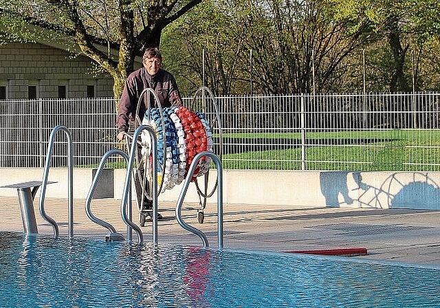 Noch sind letzte Arbeiten zu erledigen, bevor am Samstag die Badi öffnet: Badmeister Georges Hächler mit den Schwimmleinen. Foto: Carolin Frei