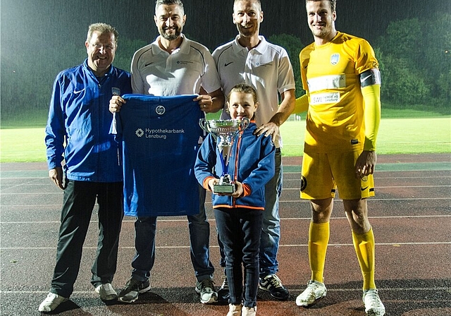 Pokalübergabe: Alissia hält den Pokal ganz fest; oben von links Co-Präsident Ueli Bruder, Fabrizio Castagna (Hypi Suhr), Renato D’Angelo (Hypi Rupperswil) und Stephan Wernli, Vize-Kapitän FC Lenzburg. Foto: Peter Winkelmann