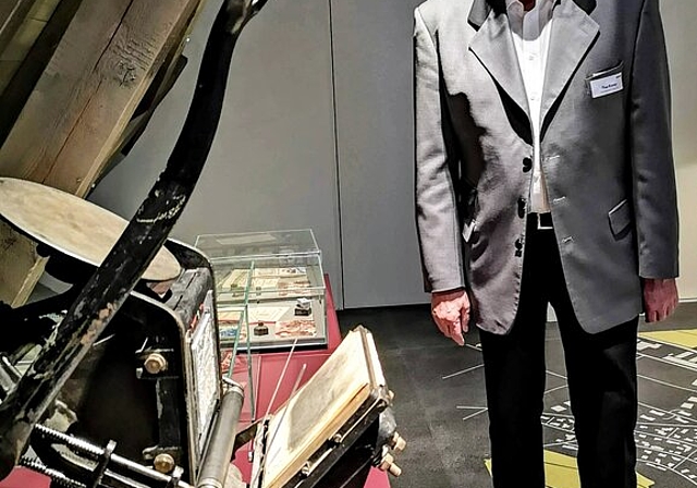 <em>Keineswegs reif fürs Museum:</em> Senior Consultant Theo Kromer neben einer Druckpresse in der PopUp-Ausstellung.