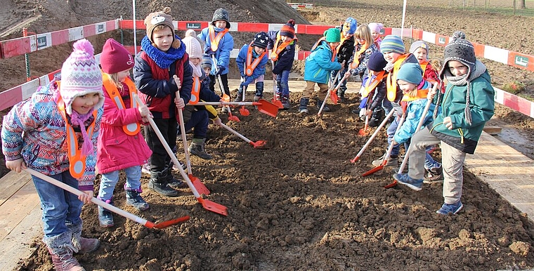 Beitrag zum neuen Kindergarten: Kindergärtler graben wacker mit. Foto: Alfred Gassmann