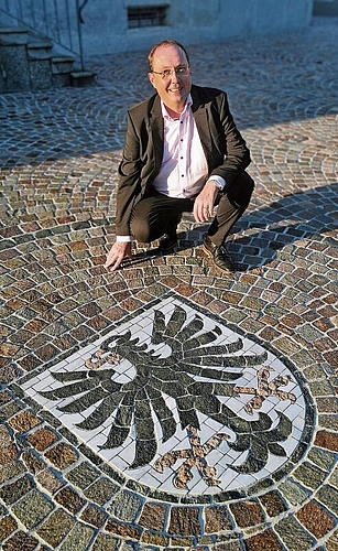 Stolz: Gemeindeammann Jörg Bruder neben dem gepflästerten Seenger Mosaikwappen. Foto: Fritz Thut