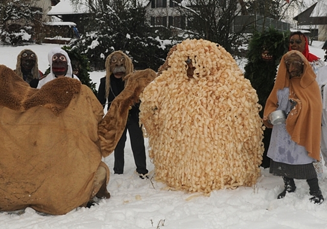 Die Bärzeli-Gruppe im Schnee: Sie besteht aus 15 erwachsenen, ledigen Burschen aus dem Dorf, die eine Maske tragen, die ihr Wesen charakterisiert.