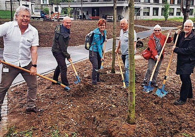 Mit vereinten Kräften: Mitglieder des Alterszentrums und des Naturschutzvereins beim Baumpflanzen im Park. Foto: Fritz Thut