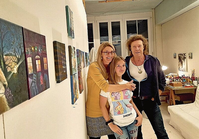 Einblick ins Atelier: Schlagzeuger Lukas Meier, Anja Voegeli und ihre Tochter Mariel Knapp vor den ausgestellten Bildern ihrer Geschichte über Fuchs und Luchs. Foto: Stefanie Osswald