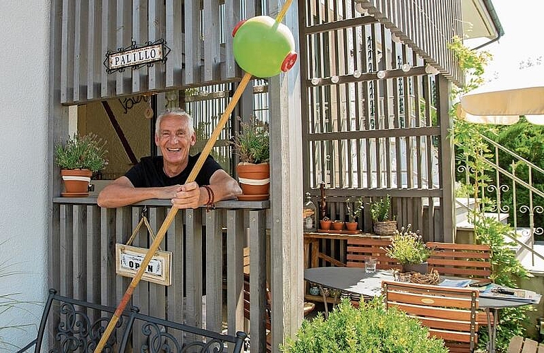 Zahnstocher als Symbol: Roland Weibel mit dem Riesenzahnstocher mit Olive als Namensgeber für die Besenbeiz. Foto: Peter Winkelmann
