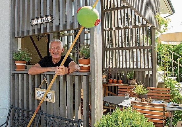 Zahnstocher als Symbol: Roland Weibel mit dem Riesenzahnstocher mit Olive als Namensgeber für die Besenbeiz. Foto: Peter Winkelmann
