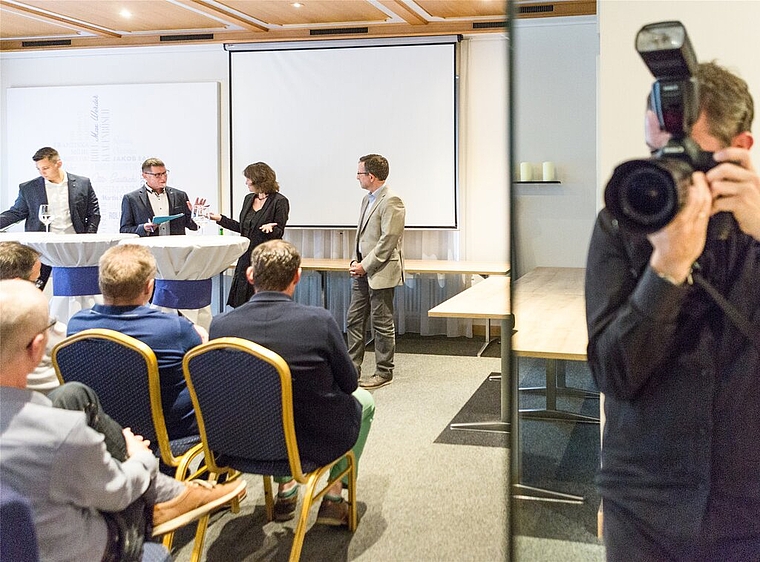 Im Fokus: Podium der drei Stadtratskandidaten im Restaurant Echt mit Andreas Schmid (FDP), Moderator Jörg Kyburz, Beatrice Burgherr (SP), Beat Hiller (GLP) und dem gespiegelten Fotografen. Foto: Chris Iseli