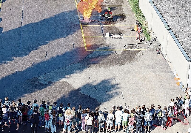 Stichflamme, wenn Wasser in Fettbrand gegossen wird: Rund einhundert Kinder beobachten die Feuerwehrdemonstration. Foto: Tanja Isler