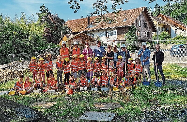 Spatenstich für den neuen Kindergarten: Die Kindergärtler mit ihren Lehrerinnen und den Involvierten, unter anderem dem Gemeindeammann Ulrich Salm (3. von rechts) und dem Architekten Markus Fankhauser (rechts aussen). Foto: Carolin Frei