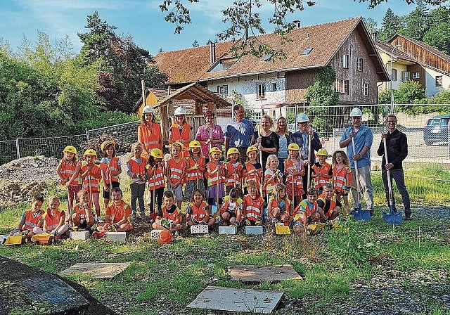 Spatenstich für den neuen Kindergarten: Die Kindergärtler mit ihren Lehrerinnen und den Involvierten, unter anderem dem Gemeindeammann Ulrich Salm (3. von rechts) und dem Architekten Markus Fankhauser (rechts aussen). Foto: Carolin Frei