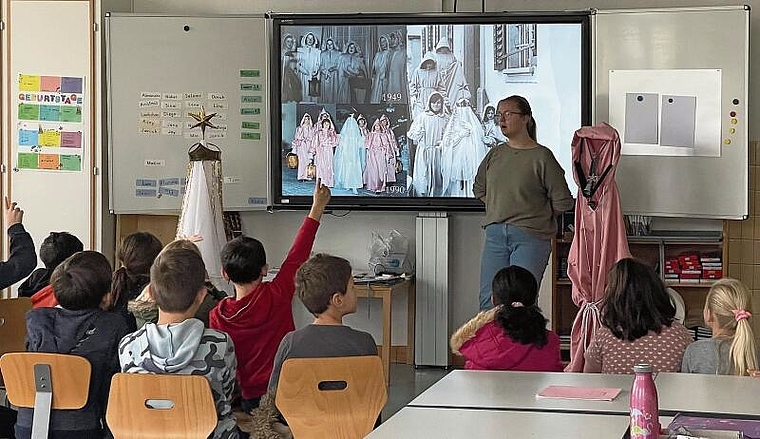 Schüler als interessierte Zuhörer: Tamara Stumpf erklärt den Hallwiler Brauch des «Wiehnechts-Chindli». Foto: Andreas Walker