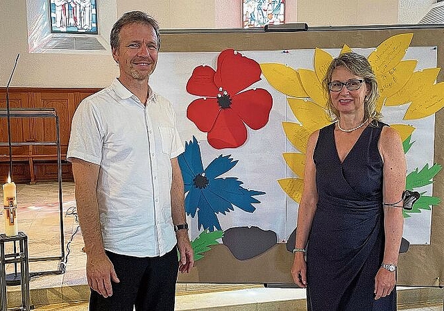 Vor einer Collage aus guten Wünschen: Pfarrer Martin Kuse mit seiner scheidenden Kollegin Ursula Vock. Foto: Hanny Dorer