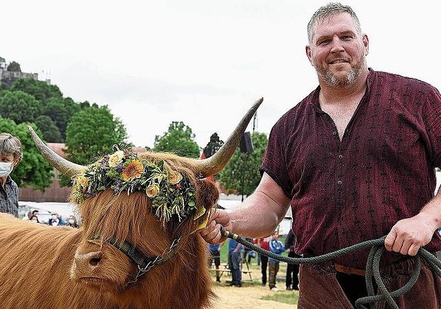 Bärbeli bleibt hier: Schwingerkönig Christian Stucki posiert mit dem Siegerpreis, dem schottischen Hochlandrind von Züchterin und Spenderin Brigitte Vogel (hinten links). Foto: Alexander Wagner
