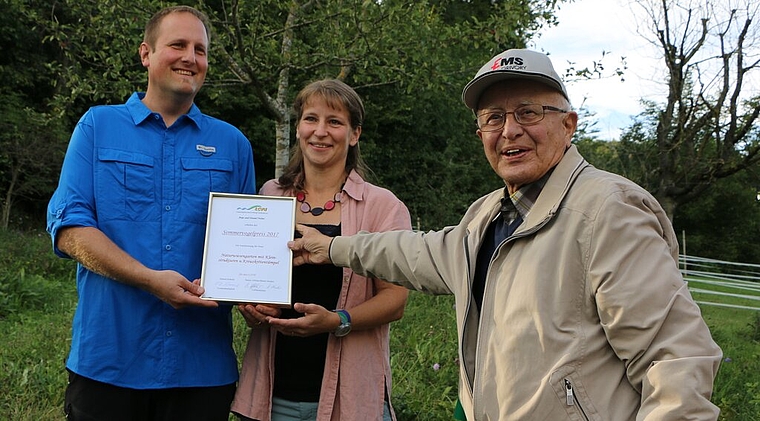 Ausgezeichnet: Eduard Schmid (rechts) vom Landschaftsschutzverband Hallwilersee überreicht Anja und Daniel Huber den Sommervogelpreis. Foto: Melanie Solloso