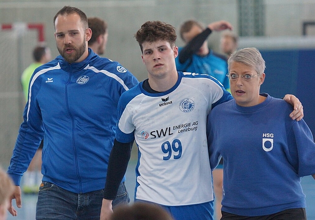 <em>Schmerzen im letzten Heimspiel der Saison:</em> Topskorer Stefan Burgherr (Mitte) wird beim 26:17-Sieg über Langenthal von Assistenztrainer Roman Hintermann und Pflegerin Andrea Wüst vom Feld begleitet. Foto: Ruedi Burkart