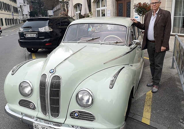 <em>Gastgeber mit eigenem Oldtimer:</em> Martin R. Bertschinger, der Präsident des Schweizer Motor-Veteranen-Clubs, mit seinem BMW 502A, Jahrgang 1956, 2,6 Liter V8, vor dem LBA-Gebäude in Lenzburg, Foto: Fritz Thut