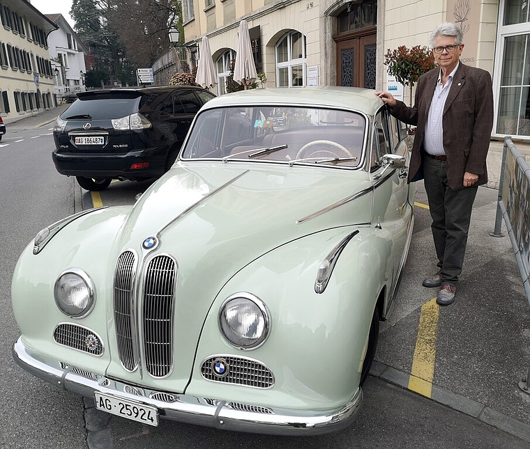 <em>Gastgeber mit eigenem Oldtimer:</em> Martin R. Bertschinger, der Präsident des Schweizer Motor-Veteranen-Clubs, mit seinem BMW 502A, Jahrgang 1956, 2,6 Liter V8, vor dem LBA-Gebäude in Lenzburg, Foto: Fritz Thut