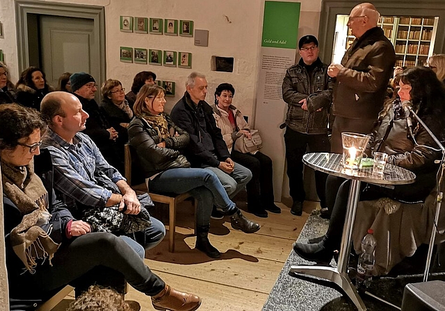 <em>Viel erwartungsvolles Publikum im winterkalten Schloss Hallwyl:</em> Max-Albrecht Fischer, Präsident der Gesellschaft zum Falken und Fisch, begrüsst Wicca Meier-Spring zur Gespensternacht. Foto: Fritz Thut