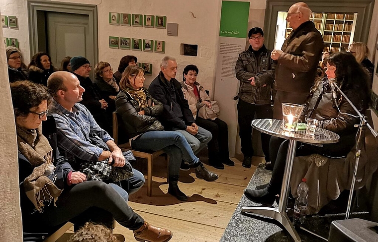 <em>Viel erwartungsvolles Publikum im winterkalten Schloss Hallwyl:</em> Max-Albrecht Fischer, Präsident der Gesellschaft zum Falken und Fisch, begrüsst Wicca Meier-Spring zur Gespensternacht. Foto: Fritz Thut