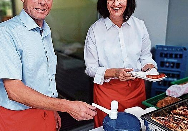 Bedienten Bürger mit Bratwürsten: Vizeammann Thomas Lindenmann und Gemeinderätin Susanne Rölli. Foto: Fritz Thut