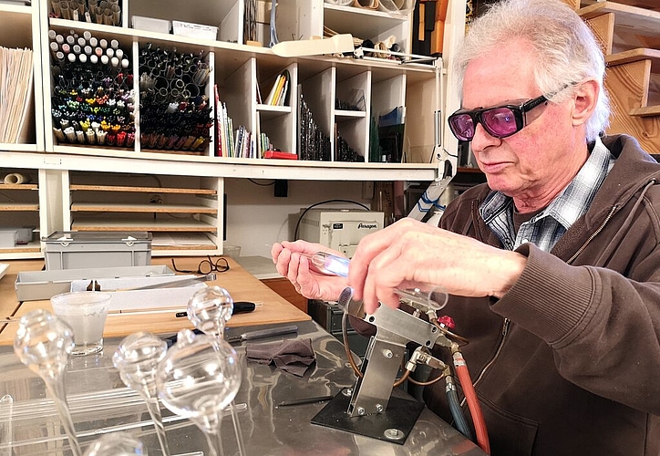 <em>Mit Schutzbrille ausgerüstet am Werken:</em> Glaskünstler Hans-Peter Eichenberger in seinem Atelier am Keltenweg. Fotos: Fritz Thut